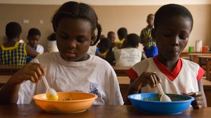 Unos ni&ntilde;os comen en el comedor de su colegio en Ghana.