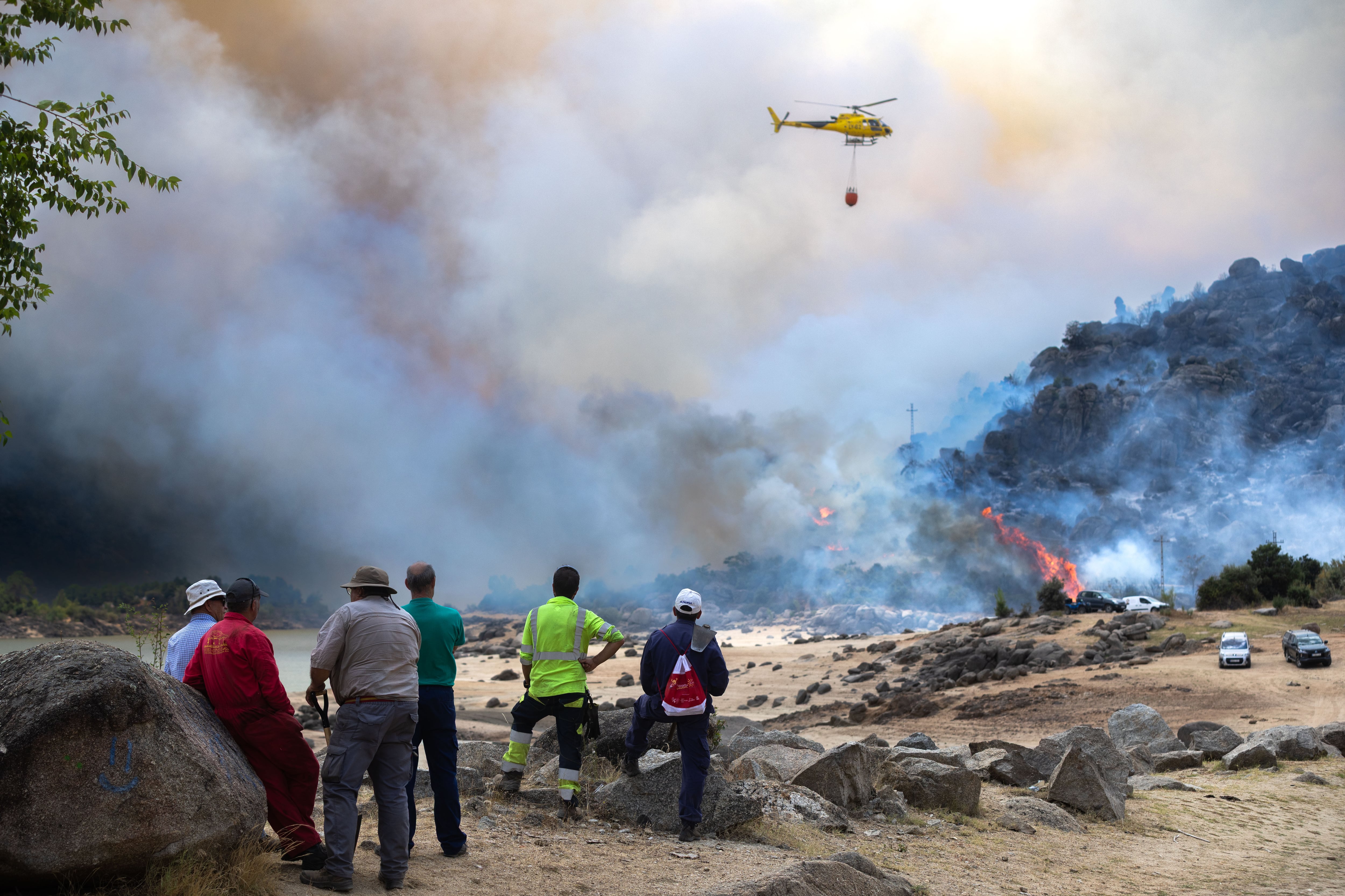 Algunos curiosos observan el incendio sobre el embalse del Burguillo (Ávila).