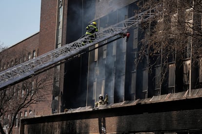 Bomberos inspeccionan el edificio afectado por el incendio en la ciudad más grande de Sudáfrica.