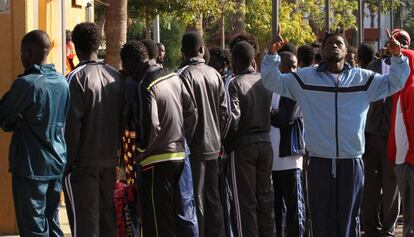 Un grupo de subsaharianos hacen cola frente a la enfermería del CETI de Melilla