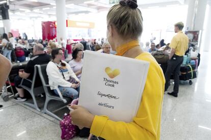 Una trabajadora de Thomas Cook informa a los pasajeros en el aeropuerto de Palma de Mallorca, este lunes.