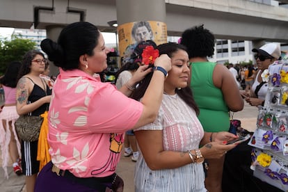 Mujeres adornan su cabello con flores antes del concierto.