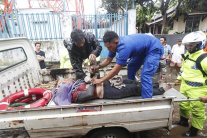 As equipes de resgate transportam o corpo de uma das vítimas do tsunami na Indonésia.