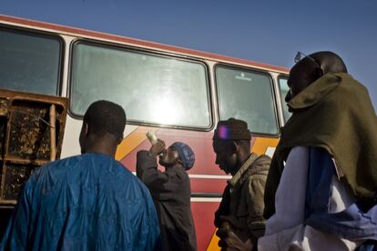 Viajeros en una parada de la ruta Bamako Mopti se refrescan antes de volver al autobús. En las distintas estaciones del recorrido los pasadores esperan a los posibles candidatos que quieren continuar su viaje por Argelia.