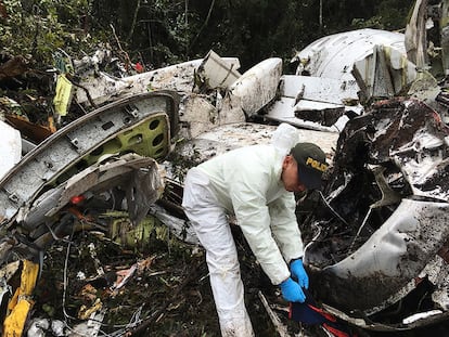 Un agente de la policía trabaja cerca de los restos del avión siniestrado en La Unión (Colombia).