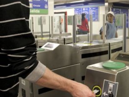 Un usuario introduce su billete en el torno de entrada de una estación del metro de Madrid.