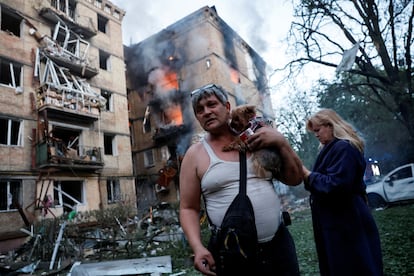 Un residente sostiene a su perro en una zona atacada por drones rusos, este martes, en Kiev.