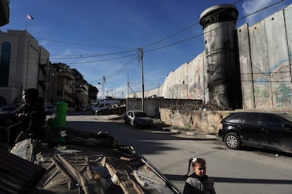 Una niña juega frente a la puerta de su casa delante del muro levantado por Israel. 