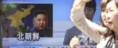 Dos personas caminan el Seul delante de un televisor donde se informa de las últimas pruebas militares realizadas por Corea del Norte.