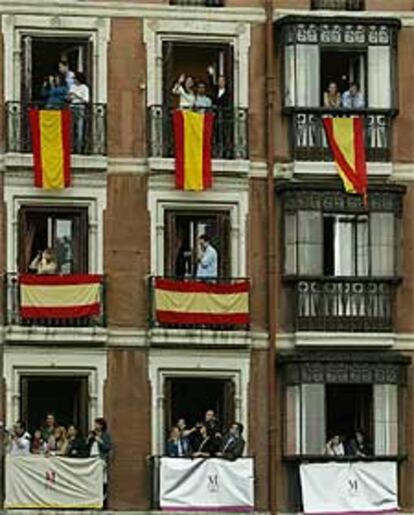 Varios espectadores aguardan el paso de la comitiva nupcial frente a la catedral de la Almudena.