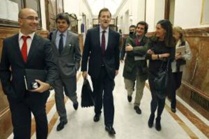 El presidente del Gobierno, Mariano Rajoy (c), tras la sesión de de control al Ejecutivo esta mañana en el Congreso.