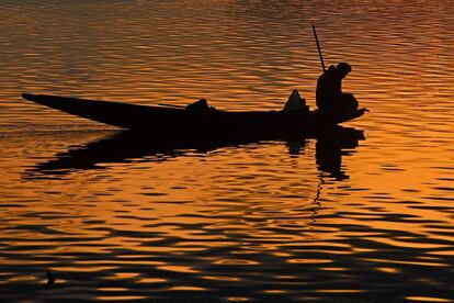 Silueta de un pescador en una barca durante el atardecer en el lago Dal, en Srinagar (India).
