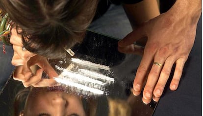 Una joven esnifa una raya de cocaína.