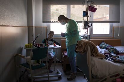 Carolina, encargada del taller de Arte Expresivo, del Hospital Sant Joan de Déu, pinta con Iván, paciente hospitalizado de 13 anos.