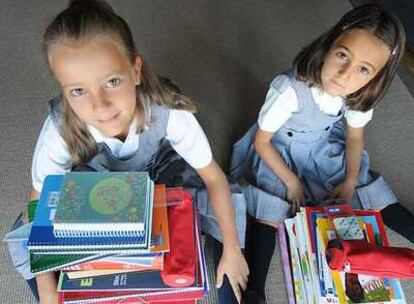 Beatriz y Alicia muestran su material escolar recién comprado.