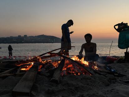 Varios vecinos preparan una hoguera durante la noche de San Juan de 2023 en la playa de Riazor (A Coruña).