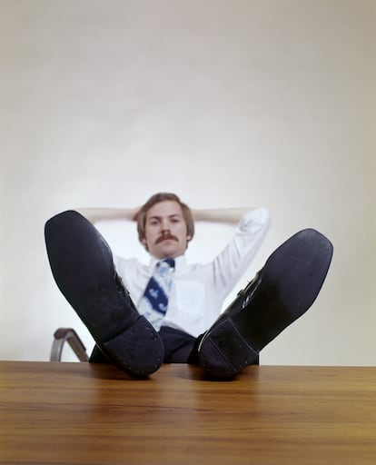 A man relaxing at the office in the 1970s. 