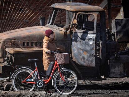 A resident walks near a destroyed Russian truck in the northeastern city of Trostianets, on March 29, 2022. - Ukraine said on March 26, 2022 its forces had recaptured the town of Trostianets, near the Russian border, one of the first towns to fall under Moscow's control in its month-long invasion. (Photo by FADEL SENNA / AFP)