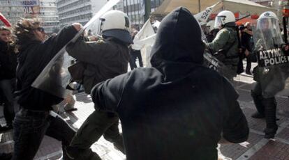 Enfrentamiento entre la policía y un grupo de manifestantes al término de la marcha de protesta que ayer recorrió Atenas.