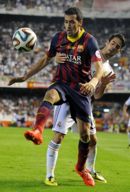 Busquets protege el balón ante Isco.