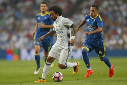 El jugador del Real Madrid, Marcelo, lucha por la pelota ante la presencia de Fabián Orellana del Celta de Vigo.
