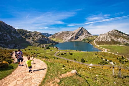 Visitantes ante el lago Enol, en Covadonga (Asturias), uno de los lugares más visitados del parque nacional de los Picos de Europa.