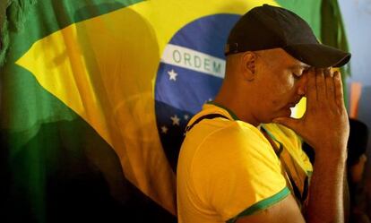 Un aficionado de Brasil reza poco antes del partido de su selección ante México.