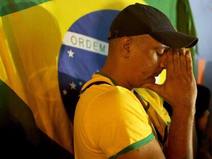 Um torcedor do Brasil reza antes da partida contra o México.