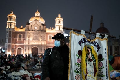 Un peregrino sostiene un estandarte con la imagen de la Virgen de Guadalupe, a las afueras de la Basílica.