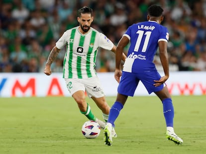 Isco conduce el balón mientras Lemar, del Atlético, le espera.