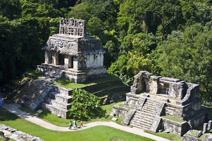 Turistas caminan por las ruinas el centro ceremonial maya de Palenque.