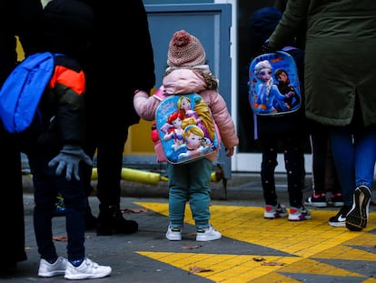 Varios niños esperan para entrar en un centro escolar de Barcelona el 11 de enero.
