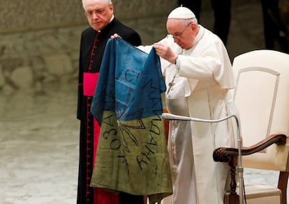 El Papa sostiene una bandera de Ucrania al término de la audiencia general celebrada en el aula Pablo VI del Vaticano. "En las recientes noticias que llegan de la guerra de Ucrania, en vez de traernos alivio y esperanza, nos traen noticias de nuevas atrocidades, como la masacre de Bucha, horrendas crueldades contra civiles, mujeres y niños indefensos", ha dicho Francisco al término del acto protocolario celebrado en el Vaticano.