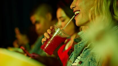 Una mujer utiliza un pitillo para beber en el cine, en una fotografía ilustrativa.
