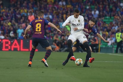 Rodrigo (centro), del Valencia, intenta hacerse con el balón ante Jordi Alba (a la derecha).