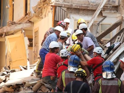 Los bomberos y técnicos rescatando a la mujer atrapada bajo los escombros del edificio derrumbado de Lleida.