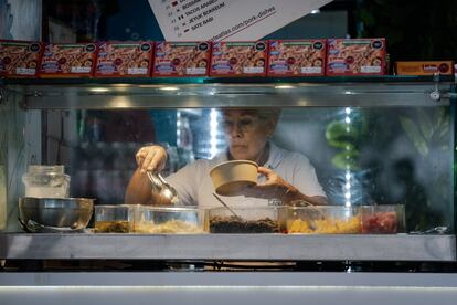 Una mujer sirve uno de los platos en uno de los restaurantes de la Zona Azul, durante la COP16, en Cali, el 28 de octubre de 2024.