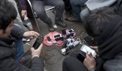 Un grupo de refugiados carga sus teléfonos en un parque de Belgrado, en Serbia, el pasado enero.