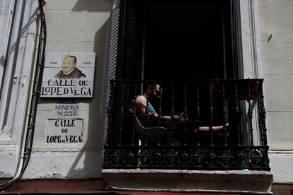 Un hombre lee en el balcón de su casa en calle Lope de Vega de Madrid el pasado 1 de mayo. 