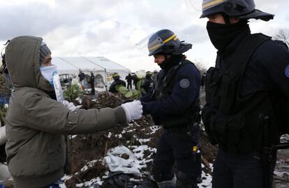 Un niño ofrece flores a la policía este lunes en una manifestación contra el desmantelamiento de la Jungla de Calais.