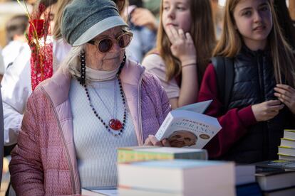 Una señora contempla un libro en los puestos de las Ramblas, en Barcelona, esta mañana.