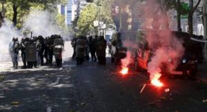 Agentes antidisturbios protegiéndose de algunas bengalas lanzadas por participantes en la manifestación que se desarrolló este miércoles en Madrid en apoyo de la minería del carbón.