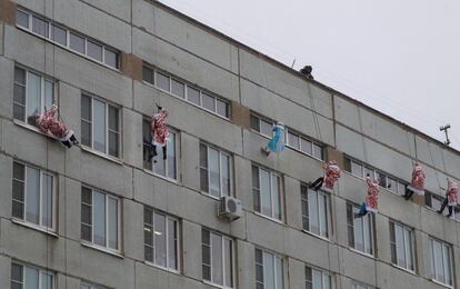 Bomberos rusos vestidos de 'Ded Moroz', el Papá Noel ruso, trepan por la fachada del hospital pediátrico Morozovskaya en Moscú (Rusia).