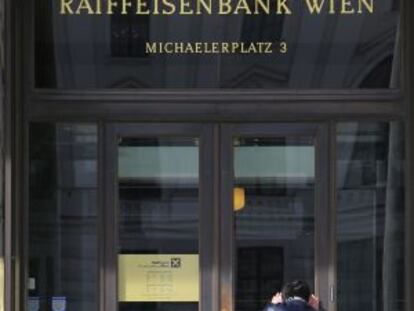 Un hombre mira por la puerta de un banco en Viena.