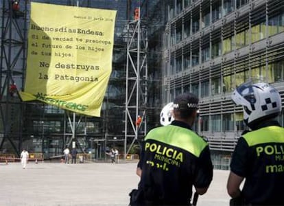 Cuatro activistas colgados de la fachada de la sede de Endesa en Madrid descuelgan una pancarta contra la construcción de cinco grandes presas en la patagonía chilena.