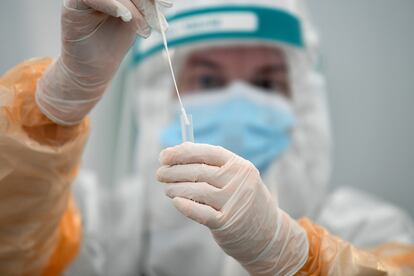 Un técnico de laboratorio sujeta una muestra en un centro de pruebas de coronavirus en el aeropuerto de Dublín, en Irlanda.