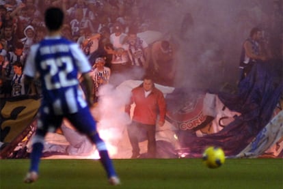 Los hinchas lanzan una bengala al césped de Riazor.