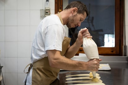 Ricard Jambert, pastelero y copropietario de Can Padrés, poniendo crema pastelera en los 'xuixos'. 