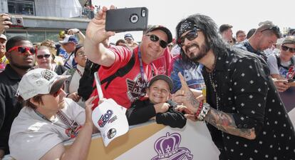 El bajista Nikki Sixx de la banda heavy Mótley Crüe se fotografía con un aficionado.