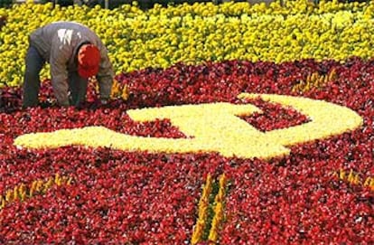 Un jardinero arregla la alfombra de flores en la que se dibuja la hoz y el martillo en vísperas del Congreso del PCCh.